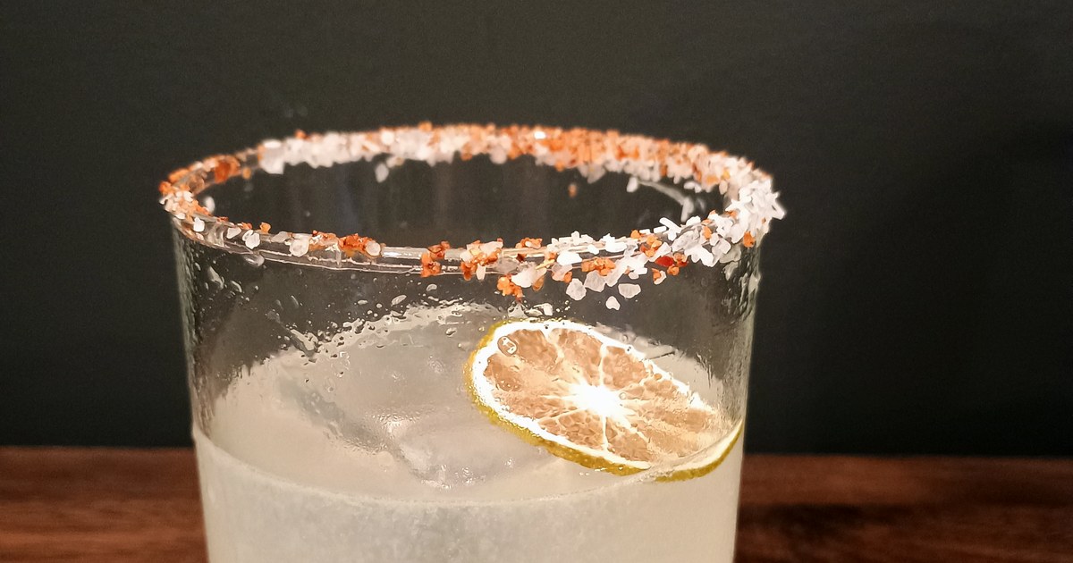 Margarita over ice with a salt-and-Tajín rim and a dried lime wheel, in a frosted rocks glass